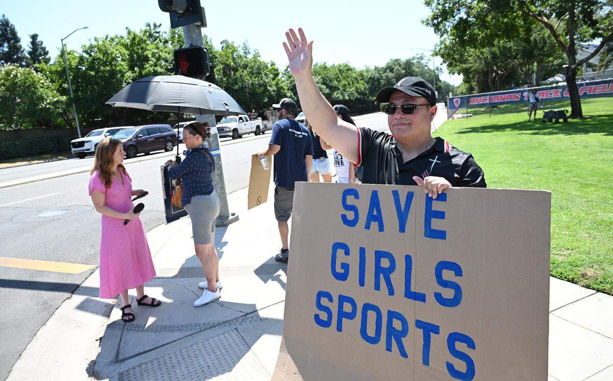 Fernando Banuelos from Parlier, right, joins about 10 protesters outside Veteran’s Memorial Stadium to push back against a trans athlete participating in the CIF Track & Field championship qualifying events Friday, May 30, 2025 in Clovis.