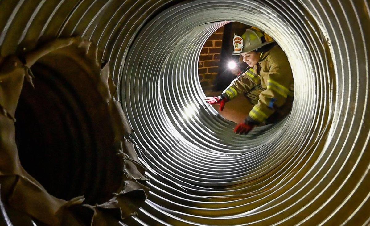 Alexa Dandridge prepares to crawl through drainage pipes to experience a search-and-rescue scenario during the Fresno Fire Department’s annual “Firefighter for a Day” event where citizens can get an inside look at the job of a firefighter, at the department’s training grounds in Fresno on Saturday, Oct. 22, 2022.