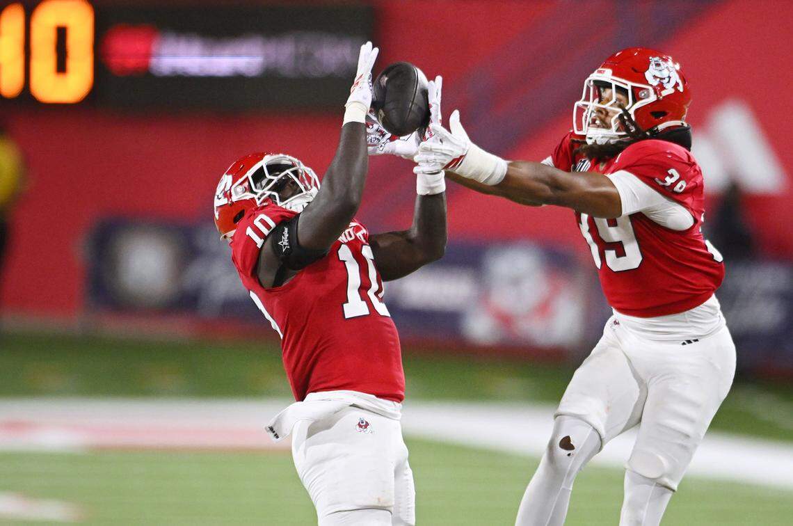 Fresno State's K'vion Thunderbird, left, intercepts Nevada's ball with Jadon Pearson covering on the right during the first half Saturday, Oct. 4, 2025 in Fresno.