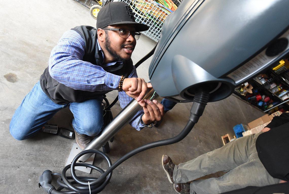 Lead technical trainer Wendell Pascacio works on an EV charging station at the ChargerHelp! warehouse in Fresno.