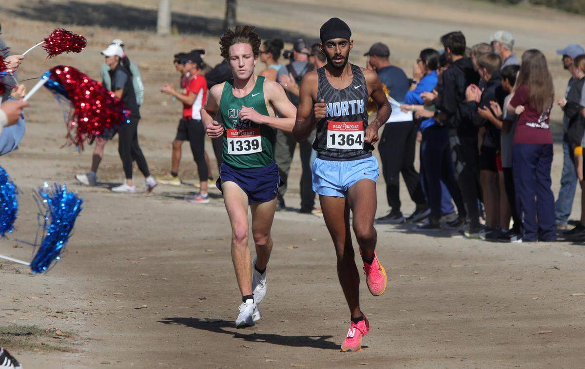 Clovis East senior Carter Spradling runs slightly behind Clovis North senior Teg Pandher with about a mile left in the TRAC cross country championships at Woodward Park on Nov. 9, 2023. Spradling won in 15:25.42; Tandher was second in 15:32.1.