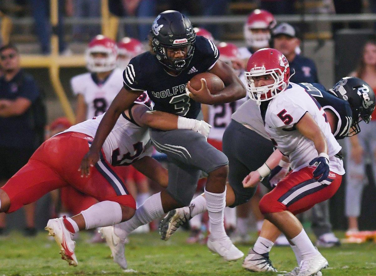 Clovis East running back Lamaj Travis, center, seen in a 2021 game against Sanger, ran for four touchdowns Friday, Sept. 23, 2022 to lead the Timberwolves to a 43-14 victory over Kerman.