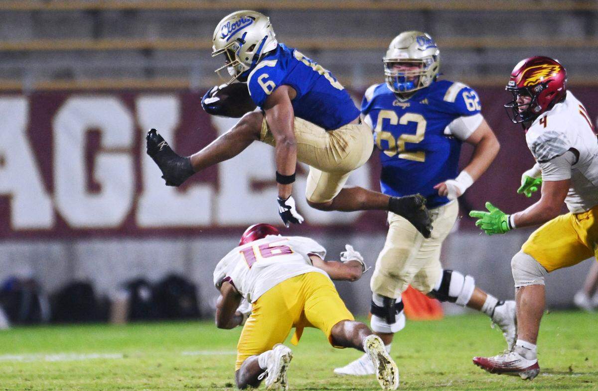 Clovis High’s James Curoso, top, hurdles over Clovis West’s Andrew Garcia, bottom in the Range Rider game held Friday, Oct. 31, 2025 in Clovis. Clovis beat out Clovis West 28–17.