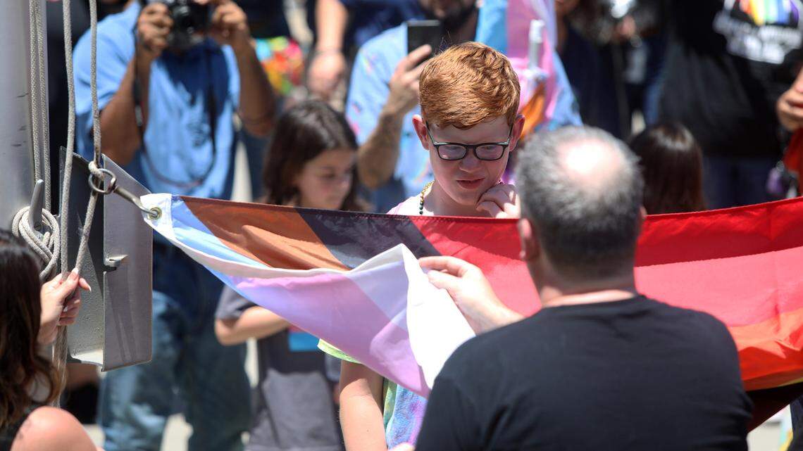 Fresno’s Kyan, 11, a contributing Dear Freedom Writer, helps raise the Pride Flag during a noontime ceremony at Fresno City Hall on June 10, 2022.