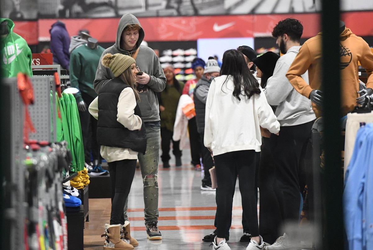 Friends gather at Dick’s Sporting Goods at River Park shopping center on Black Friday, Nov. 26, 2021.