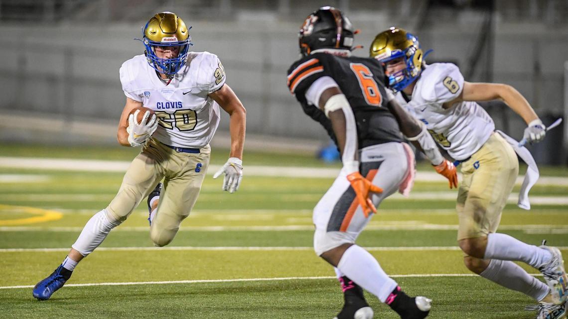 Clovis’s Tristan Risley, left, looks for an opening in the Central defense on a run during their game at Deran Koligian Stadium in Fresno on Friday, Oct. 1, 2021.
