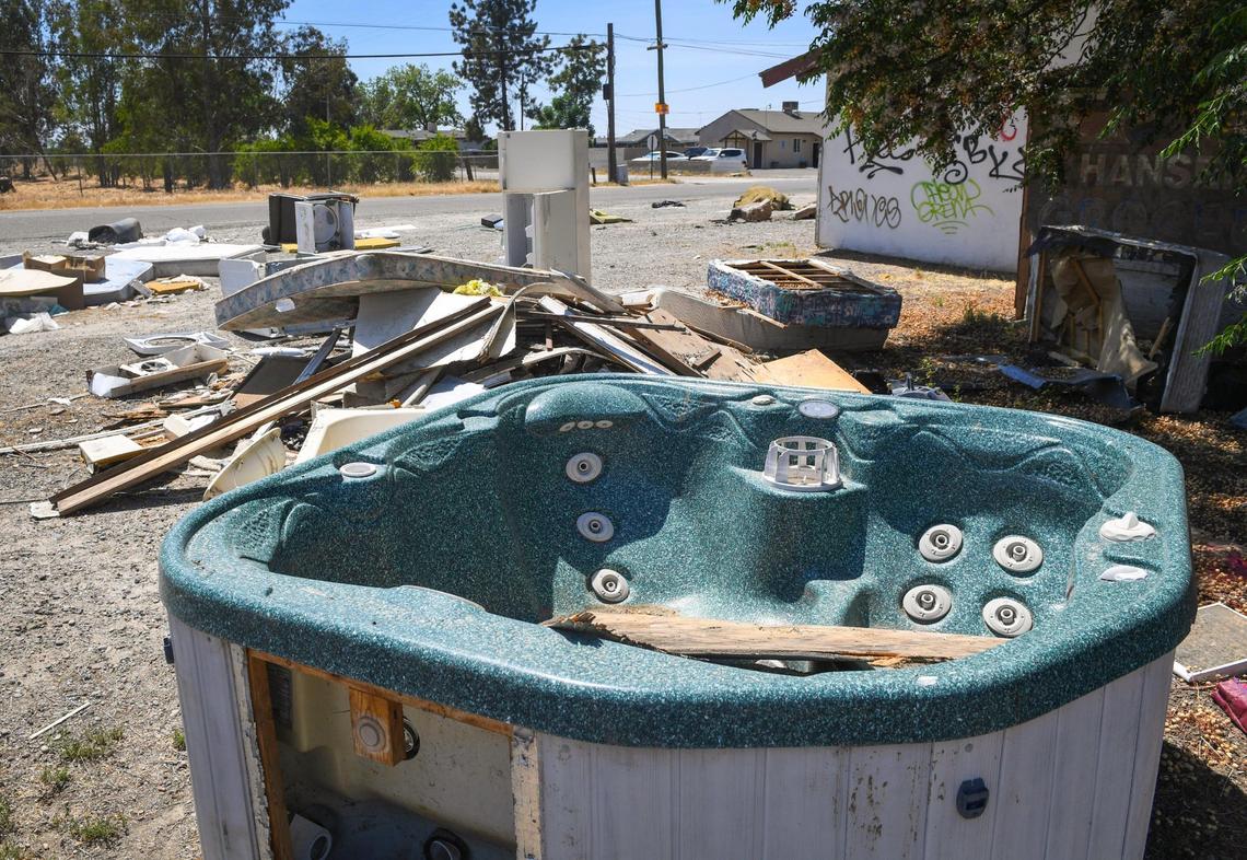 An old hot tub is among the trash, including appliances, mattresses, computer equipment, furniture and chemical containers, dumped at the corner of McKinley Avenue at Bryan west of Fresno on Friday, April 30, 2021.