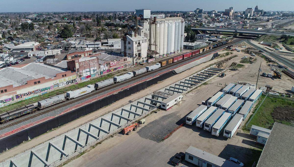 A trench section of the California High Speed Rail, at center, drops below ground level near Highway 180 and downtown Fresno during construction of the bullet train railway on Thursday, March 4, 2021.