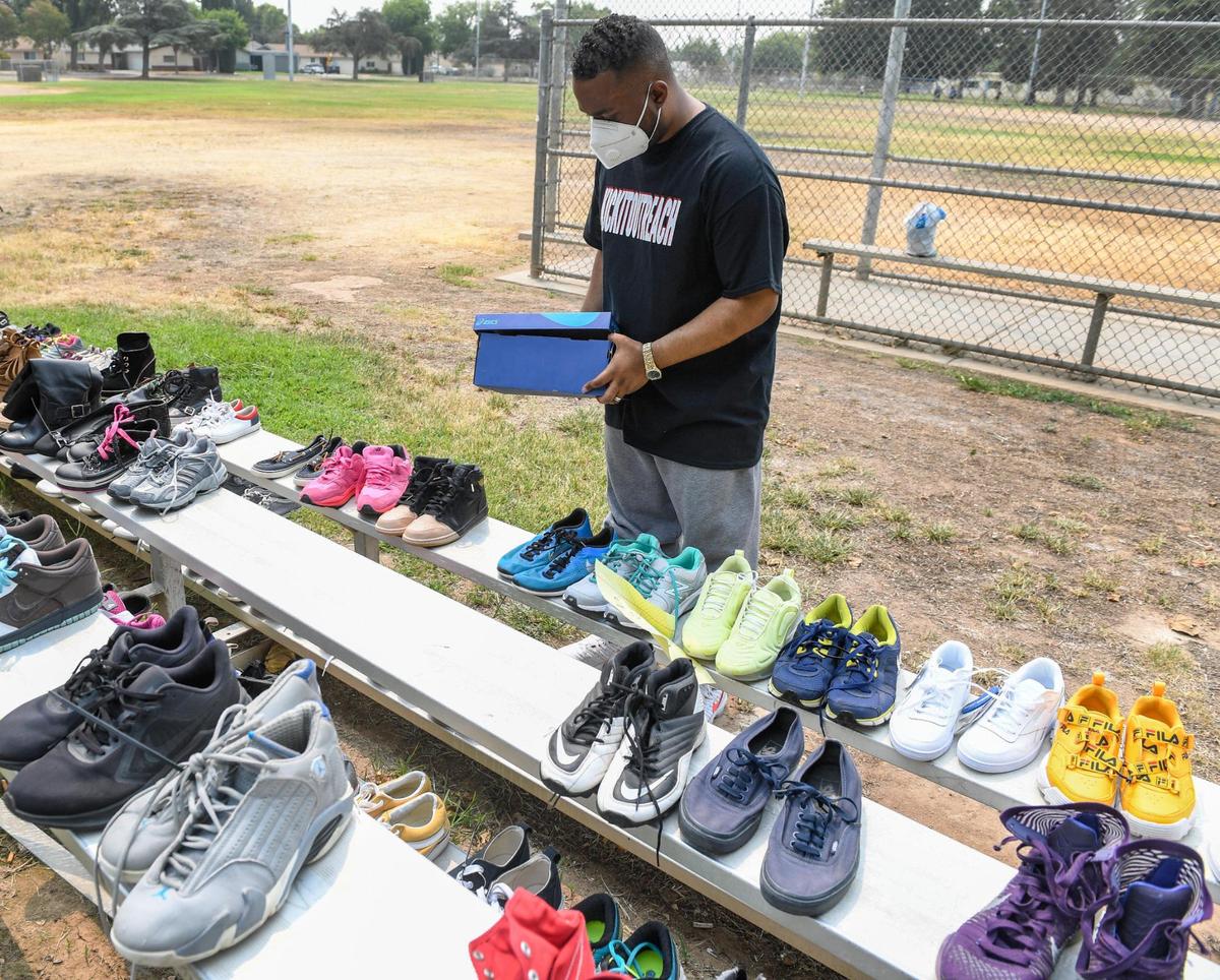 Pastor Edward Thomas checks shoe sizes while giving out shoes to families at Cary Park in Fresno during the Community Kick it Outreach shoe giveaway on Saturday, Aug. 7, 2021. Thomas started the shoe giveaway with his church Living World International Church in Fresno three years ago.