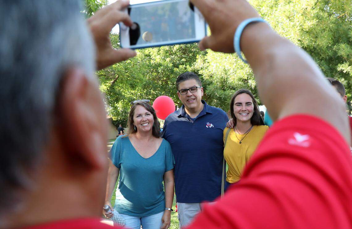Larry Salinas snaps a photo of Fresno State President Joseph I. Castro and a student and her family during Aug. 19, 2018 barbecue for dorm residents.