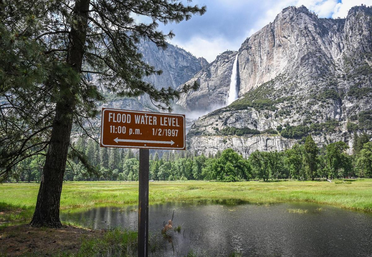 A marker shows the level of the 1997 Yosemite Valley flood while the meadow across from Upper Yosemite Falls has flooded but not nearly at that level in Yosemite Valley on Tuesday, June 13, 2023.
