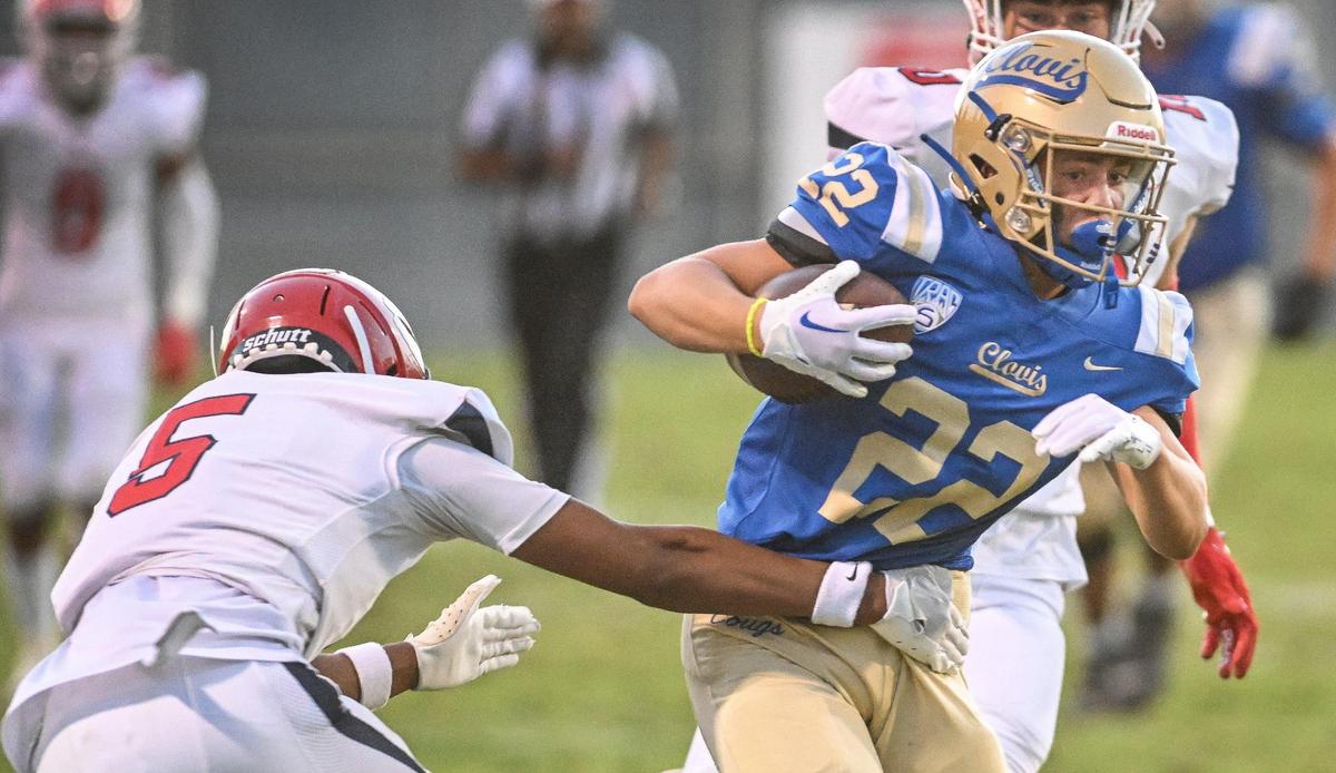 Clovis running back Maddox Merrill, right, tries to cut around Sanger’s Marquis Cropper on a run to the outside during their game at Lamonica Stadium in Clovis on Friday, Aug. 25, 2023.