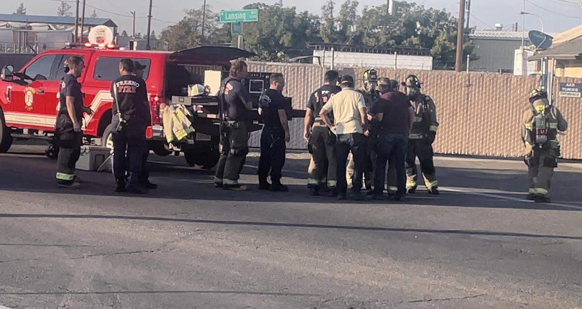 Fresno firefighters go over plans on how to safely deal with a burning lithium battery inside a Tesla at a tow yard.