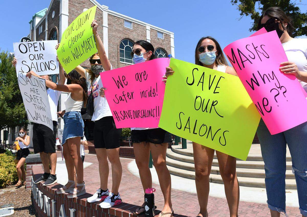Approximately 100 salon workers and supporters gather at Centennial Plaza for a rally before marching through Old Town Clovis demanding reopening and support of salons by the state Monday afternoon, Aug. 17, 2020 in Clovis.