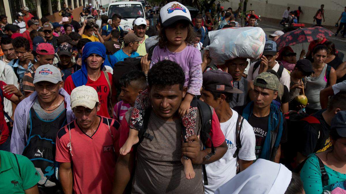 A Honduran migrant carries a little girl on his shoulders as part of a caravan making its way to the U.S., in Chiquimula, Guatemala, Tuesday, Oct. 16, 2018. U.S. President Donald Trump threatened on Tuesday to cut aid to Honduras if it doesn’t stop the impromptu caravan of migrants, but it remains unclear if governments in the region can summon the political will to physically halt the determined border-crossers.