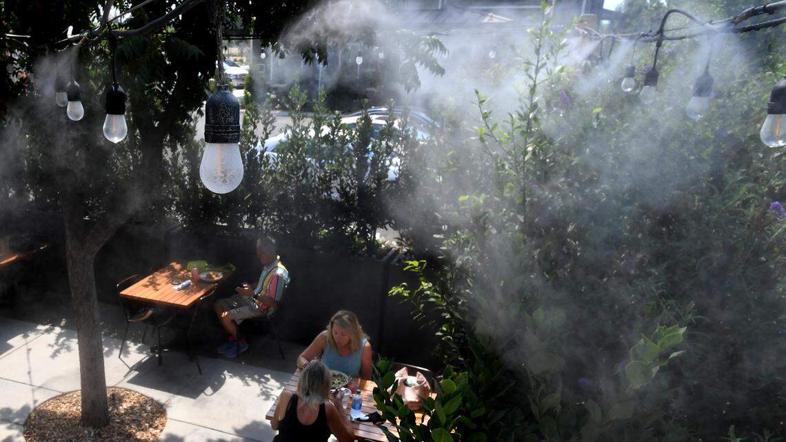 Diners at Heirloom enjoy lunch under swirling water vapors provided by misters in the restaurant’s patio in this file photo from 2020.
