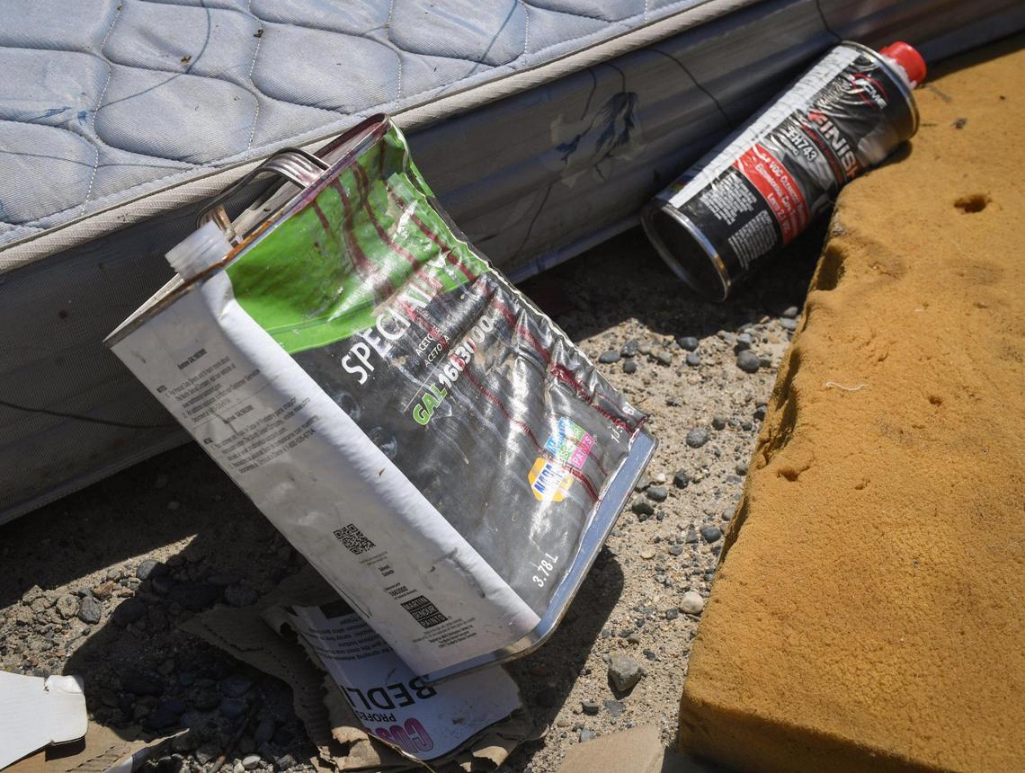 Chemical containers are among the trash dumped at the corner of McKinley Avenue at Bryan west of Fresno on Friday, April 30, 2021.