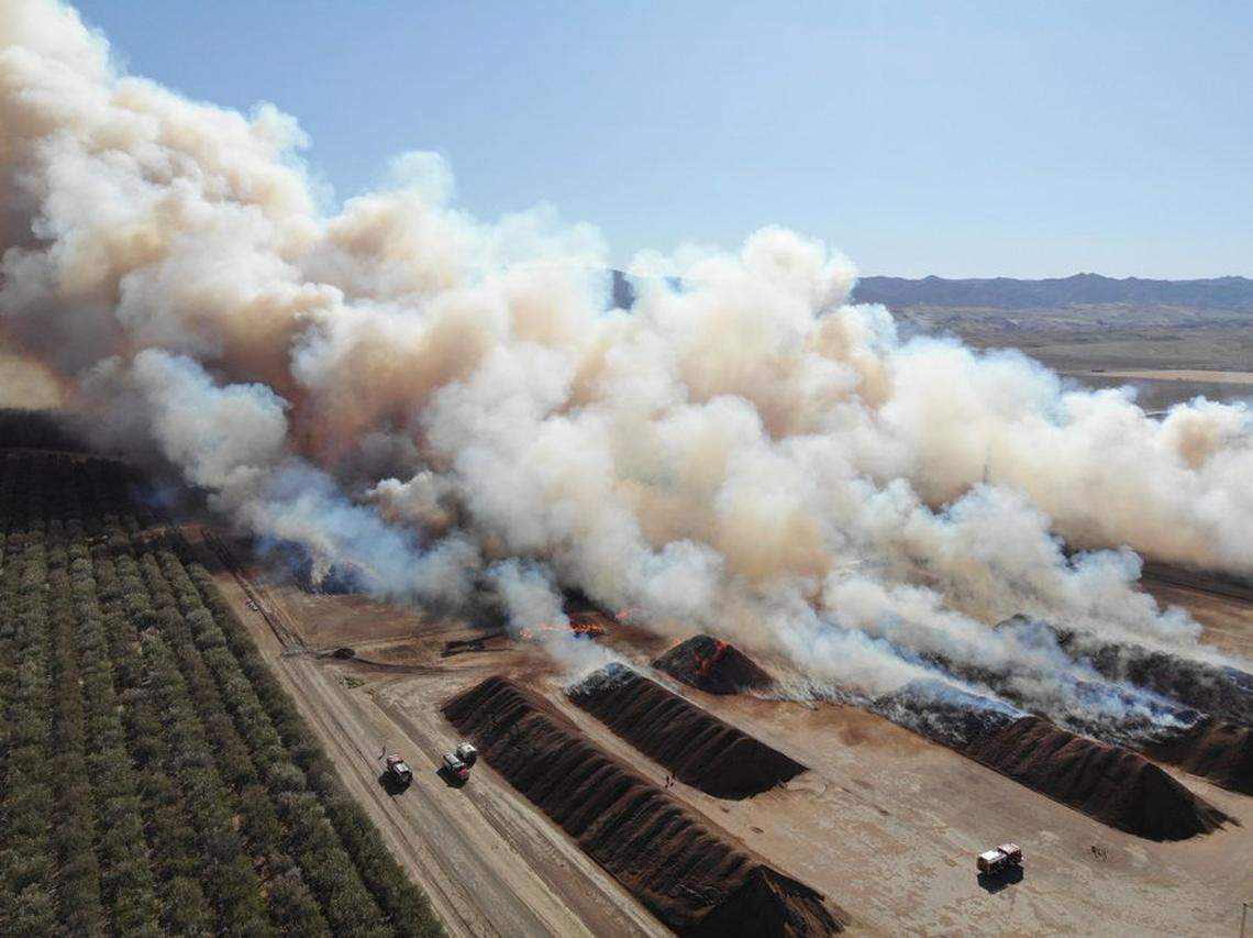 Firefighters are working hard to protect equipment and machinery while they contain a massive blaze at the Superior Almond Hulling just off Interstate 5 near Coalinga, California, crews from Cal Fire/Fresno County Fire reported Saturday, Feb. 27, 2021.