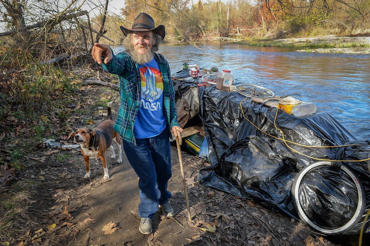 William Bell stands outside of his homemade houseboat with his dog Sailor Girl on the San Joaquin River on Thursday, Dec. 12, 2019. Bell has been living on the river on and off for four years.