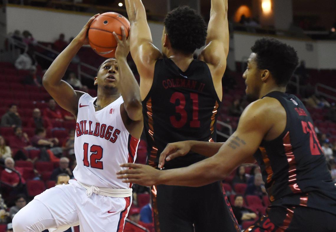 Fresno State guard Mustafa Lawrence, left, goes up for a shot against UNLV’s Marvin Coleman, center, and Nick Blair, right, in the Bulldogs’ 81-80 double overtime loss in their Mountain West opener Wednesday, Dec. 4, 2019 in Fresno. Lawrence scored 16 points and had five assists in just 21 minutes.