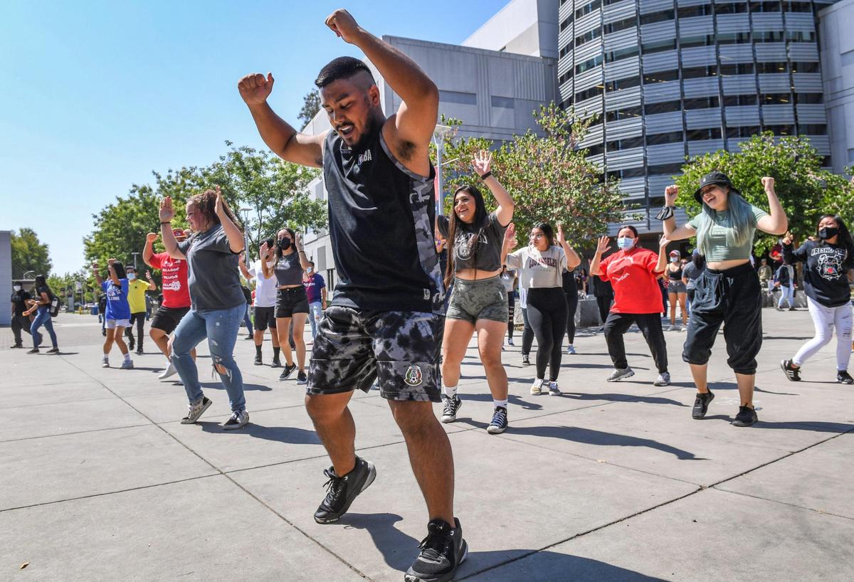 Fresno State students erupt into a flash mob of dancing during a noontime event called “Bulldogs Joyful Together” on campus near the Henry Madden Library on Wednesday, Sept. 8, 2021. Organizers called the event an opportunity for students, staff and faculty to interact and come together in celebration of our return to campus, after nearly a year and a half of working from home and distance learning.