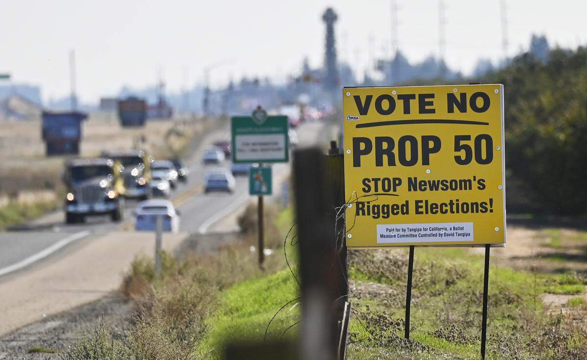 Traffic passes a Vote No On Prop. 50 sign along Highway 41 near Avenue 12 on Tuesday, Oct. 28, 2025 just north of Fresno.