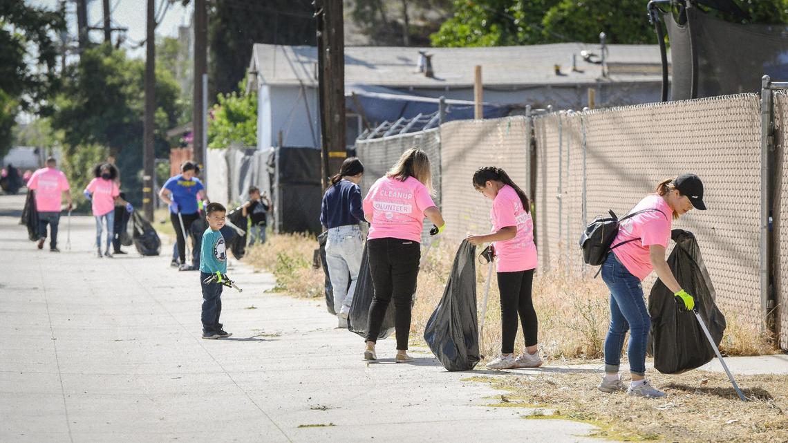 Volunteers pick up trash along an alley near Fink White Park in Fresno while participating in Beautify Fresno’s Great American Cleanup event on Saturday, April 30, 2022.