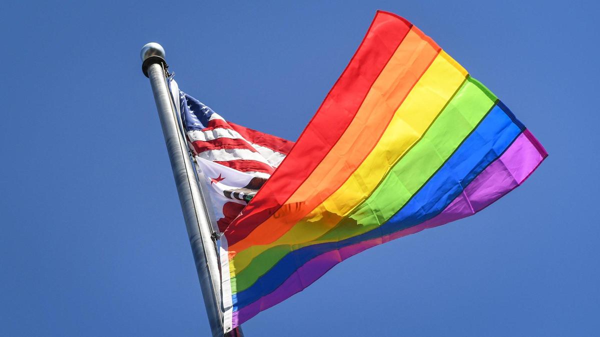 The Pride flag flies below the American and California flags on the flag pole at Fresno City College following a ceremony to recognize Pride Month on Friday, June 4, 2021. State Center Community College District trustees approved a resolution on Tuesday that recognizes June as Pride Month which led to the flag raising on Friday.