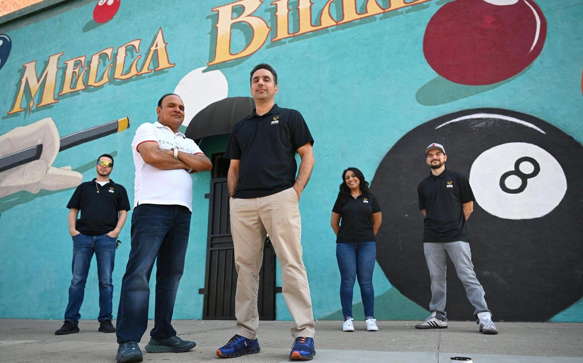 Shamsher Singh, center left, and Tony Singh, co-owners of Sierra Billiards on north Blackstone Avenue, stand in front of Mecca Billiards in Fresno’s Brewery District which they plan to open later this year if all goes as planned. Left to right in the background, Kyle Robertson, Evelin Silva and Ivan Torres. The large mural in front, painted by muralist FranCisco Vargas, may have Mecca replaced with Sierra. Photographed Monday, July 14, 2025 in Fresno.