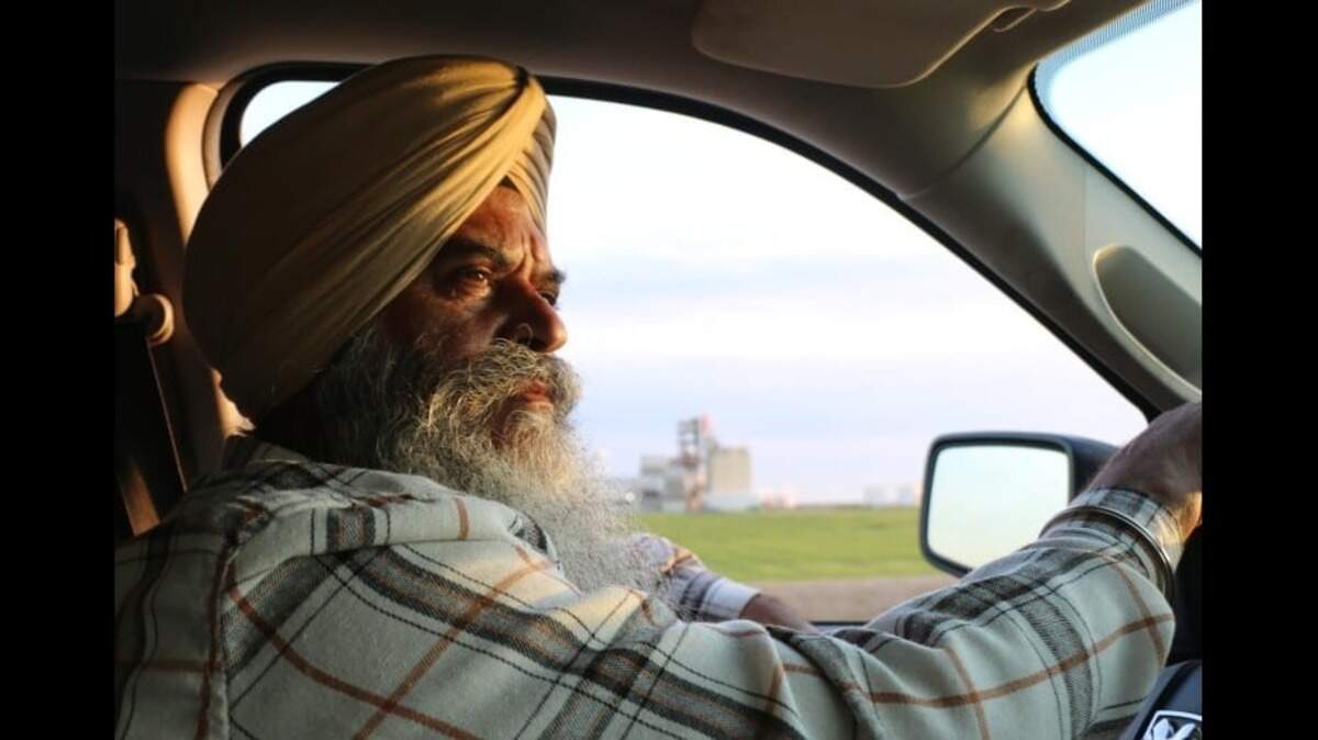 Amrik “Mickey” Singh Basra drives past a factor in Madera County near his almond ranch.