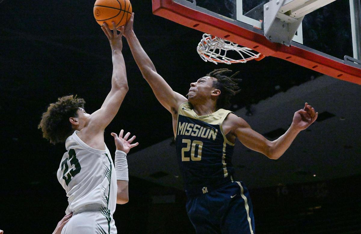 Mission Prep’s Jayden Nozil, right, blocks Dinuba’s Brice Watley’s shot, left, in the Division II game Friday, Feb. 23, 2024 in Fresno..