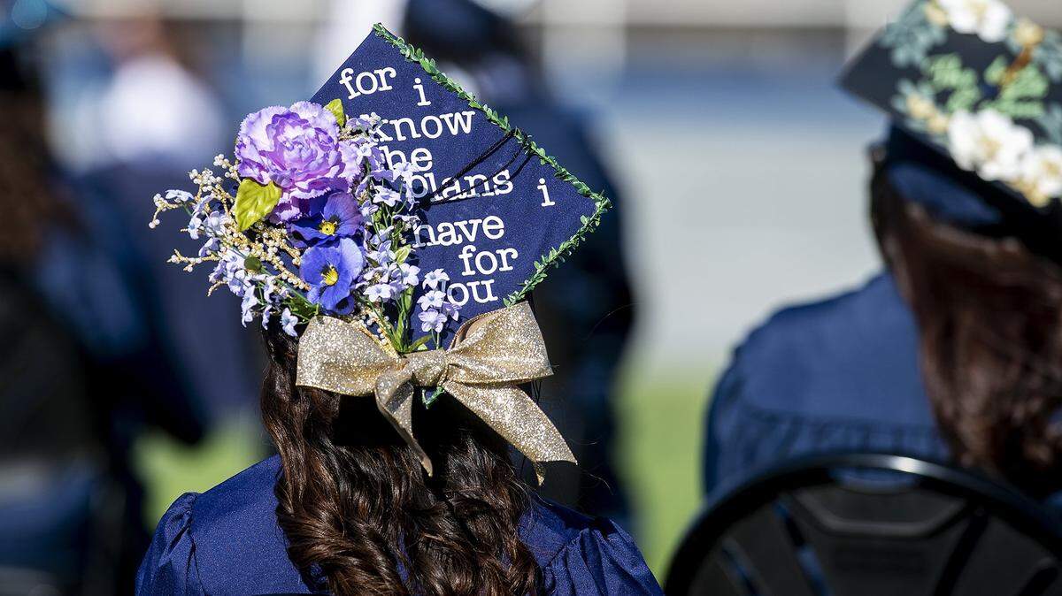 A graduate wears a decorated mortarboard hat during a commencement ceremony for the Merced College class of 2020 on Don Odishoo Field at Stadium 76 on the campus of Merced College in Merced, Calif., on Thursday, May 20, 2021.