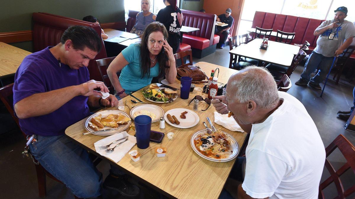 From left, Sean and Tammy Carter and Barry Halajian eat breakfast at the Waffle Shop in northwest Fresno in this 2020 file photo.