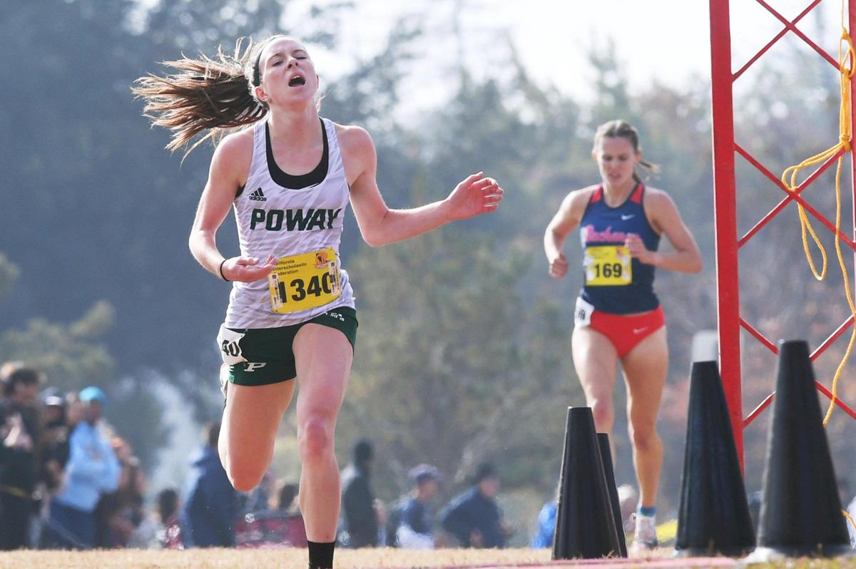 Poway’s Tessa Bushel, crosses the finish line for first place ahead of second place Grace Hutchison from Buchanan, in the background, right, in the CIF Girls D-I state cross country championship Saturday, Nov. 26, 2022 in Fresno.