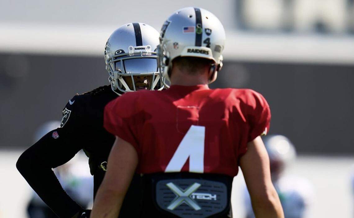 Las Vegas Raiders’ Derek Carr and Davante Adams discuss a play during a joint practice with the New England Patriots on Tuesday, Aug. 23, 2022.