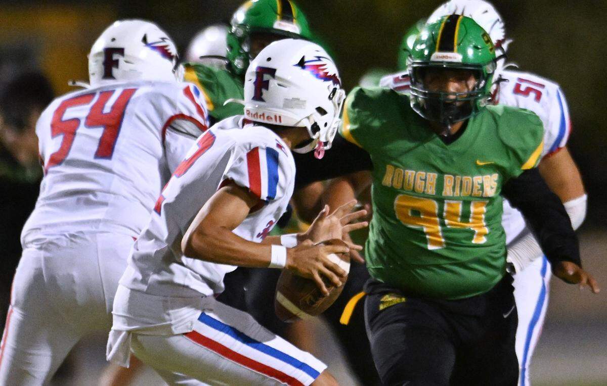 Roosevelt's Armando Roque, right, pressures Firebaugh quarterback Leonardo Perez, left, at Sunnyside's stadium Friday, Sept. 12, 2025 in Fresno. The Rough Riders pummeled the Eagles 46-6 with Firebaugh scoring their only touchdown in the final minutes of the game.