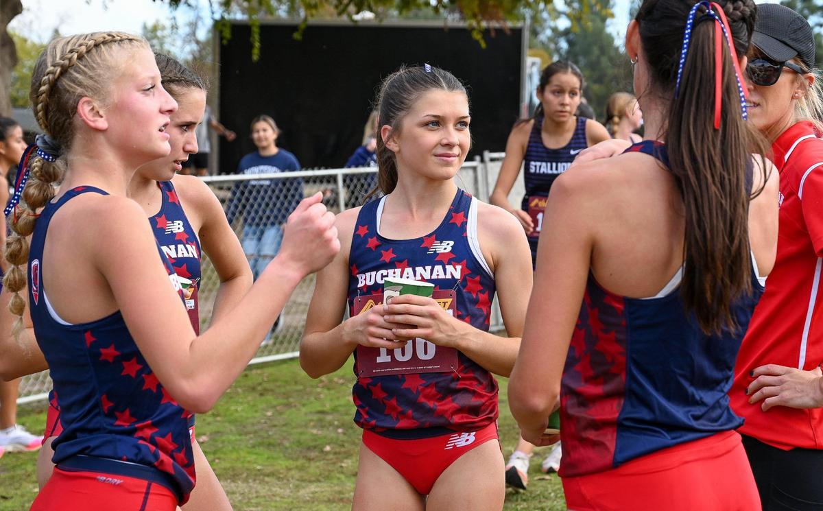 Buchanan’s Kynzlee Buckley, center, celebrates her first place finish in the Central Section girls Division 1 cross country race with teammates at Woodward Park in Fresno on Thursday, Nov. 17, 2022.