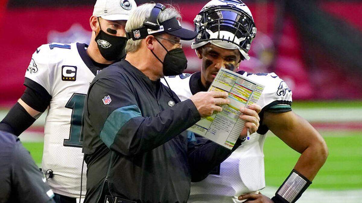 Philadelphia Eagles head coach Doug Pederson talks with starting quarterback Jalen Hurts as quarterback Carson Wentz (11) looks on during the first half of an NFL football game, Sunday, Dec. 20, 2020, in Glendale, Ariz. (AP Photo/Rick Scuteri)