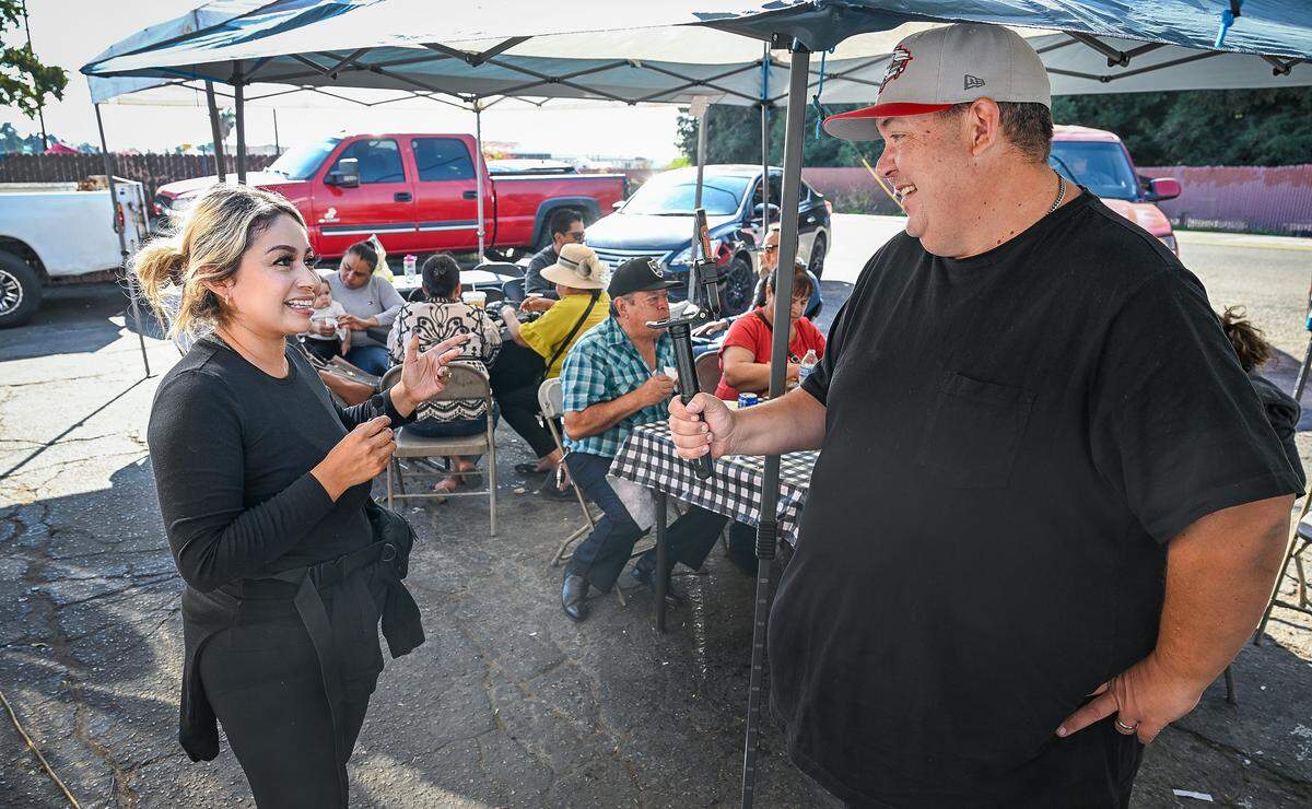 Mike Osegueda, right, who founded the Taco Truck Throwdown and Fresno Street Eats, interviews Tacos La Vaporera owner Sarah Quintero on Tuesday, Nov. 4, 2025 after delivering a special invite for the next Taco Truck Throwndown on November 8.
