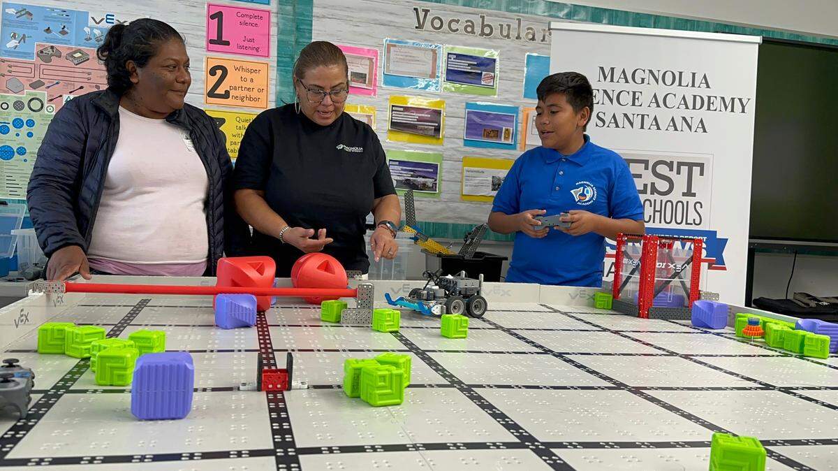 Aracely Vargas (i), su hijo, el estudiante de sexto grado Joel Rodrigue (d), y María Luisa Sánchez durante su participación en la primera Competencia Anual de Robótica VEX para Padres en la escuela Magnolia Science Academy en Santa Ana, California.