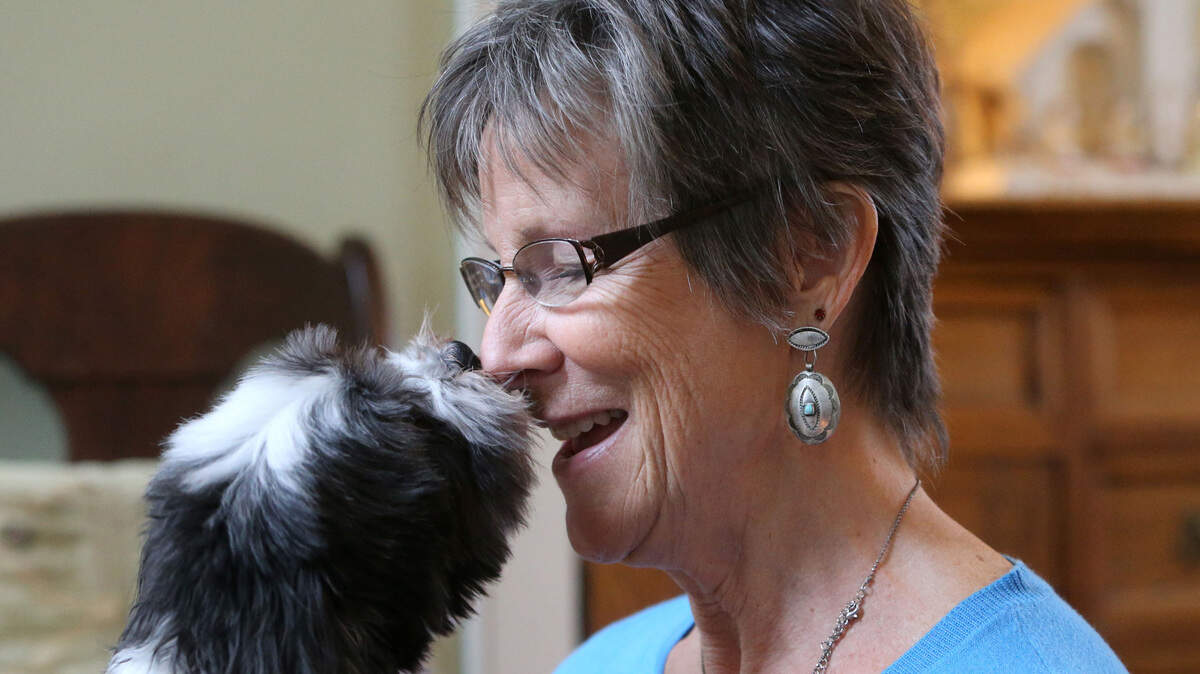 Sue Bohlmann receives attention from one of her dogs, Mateo, a Havanese, on Dec. 2, 2015 at her home in Minnetonka, Minn.