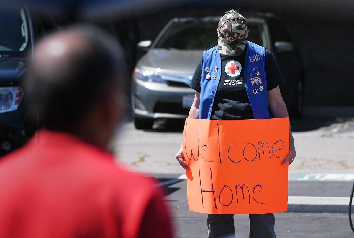 Sarah Monroe bows her head at the start of a drive through ceremony honoring service men and women in observance of National Vietnam War Veterans Day on Monday afternoon, March 29, 2021, at the Fresno Vet Center at Shaw Avenue and Sixth Street.