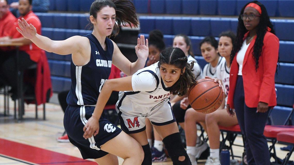 San Joaquin Memorial’s Saiya Sidhu, center, drives around Clovis East’s Kylie Ward, left, Friday, Feb. 18, 2022 in Fresno.