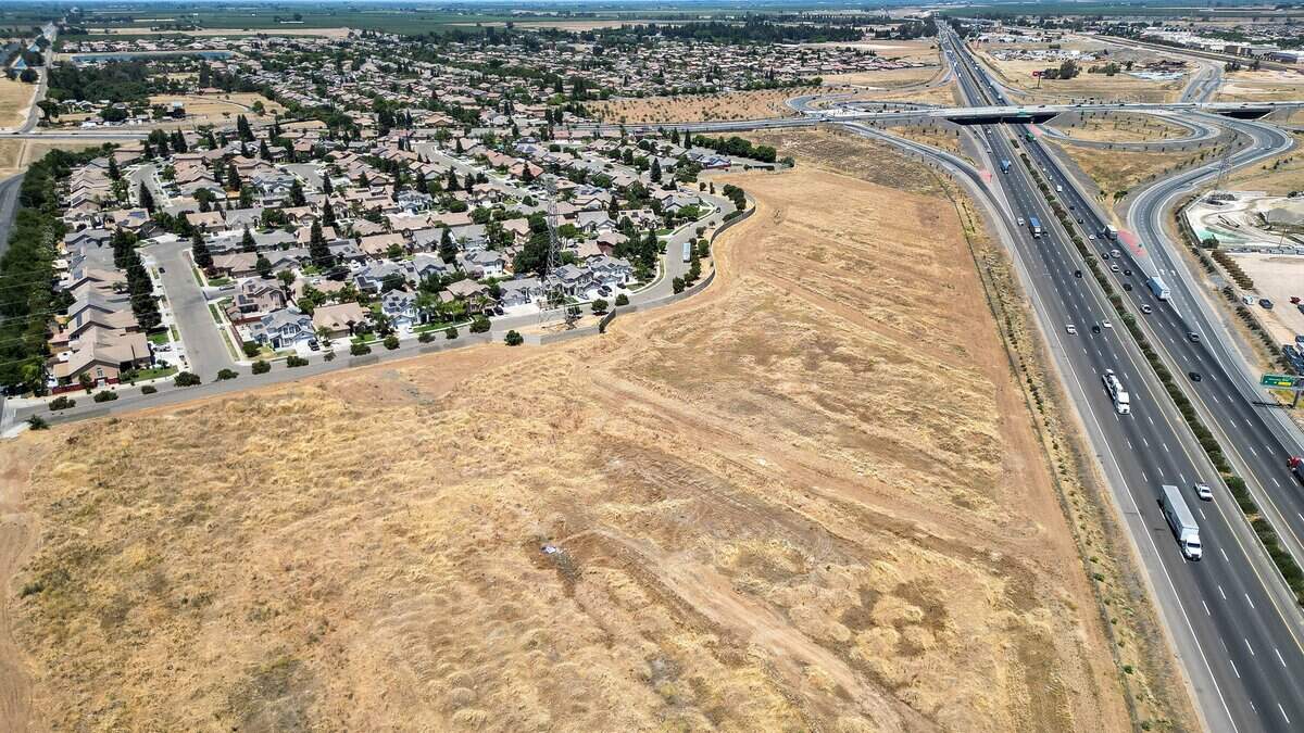 An empty lot outside between a home development and Highway 99 in west Fresno is being proposed for development into a truck parking with about 150 stalls, truck wash and repair shop plus storage units.