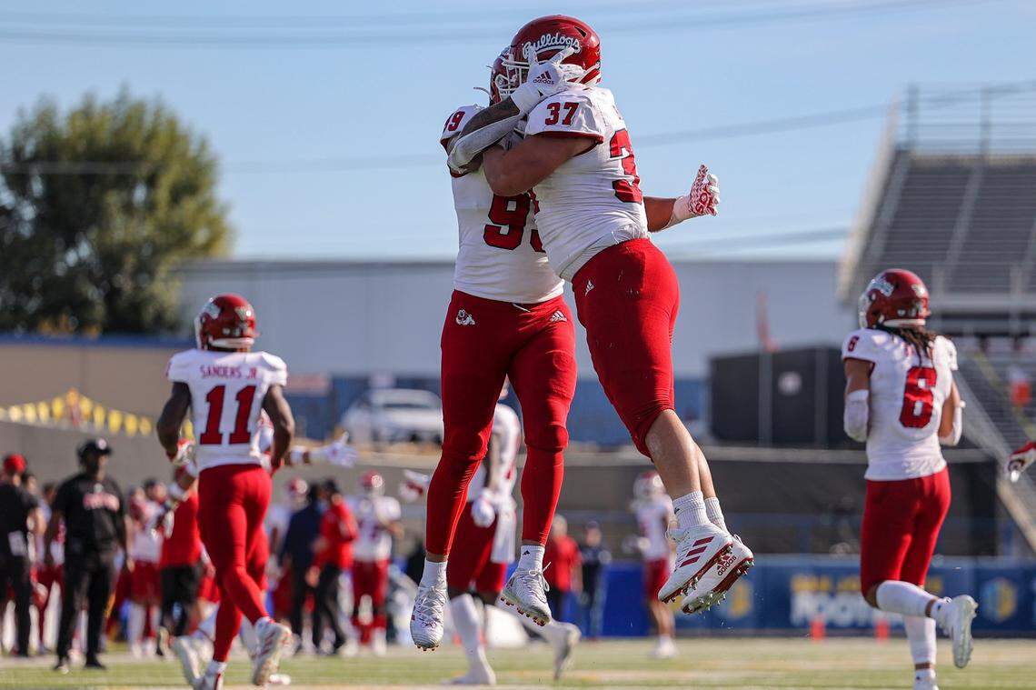 Fresno State defensive end David Perales (99) and defensive tackle Ryan Boehm (37) celebrate after San Jose State quarterback Nick Starkel was penalized for intentional grounding in the end zone, resulting in a safety.