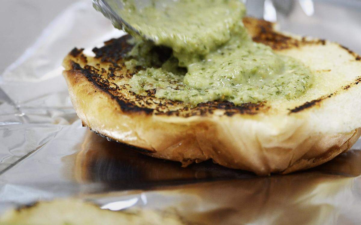 Mint Chutney is added to the bun for an Aloo Tikka Noodle Burger at Rangla Punjab Restaurant & Sweets Friday, Oct. 17, 2025 in Fresno.
