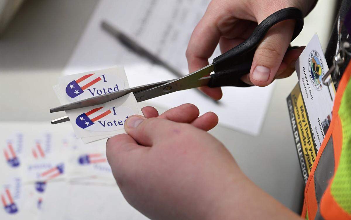 An elections workers trims “I Voted” stickers outside the downtown Fresno County Election office Tuesday, Nov. 4, 2025 in Fresno.