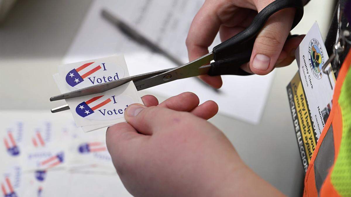 An elections workers trims “I Voted” stickers outside the downtown Fresno County Election office Tuesday, Nov. 4, 2025 in Fresno.
