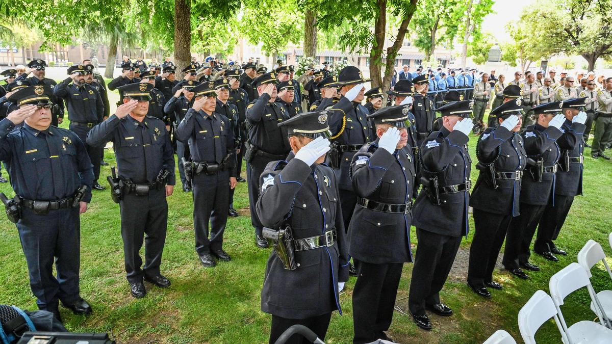 Law enforcement officers from various agencies including the Fresno Police Department, the Fresno County Sheriff’s Department and the California Highway Patrol, salute during the Fresno Peace Officer memorial ceremony honoring fallen law enforcement, in Courthouse Park on Thursday, May 5, 2022.