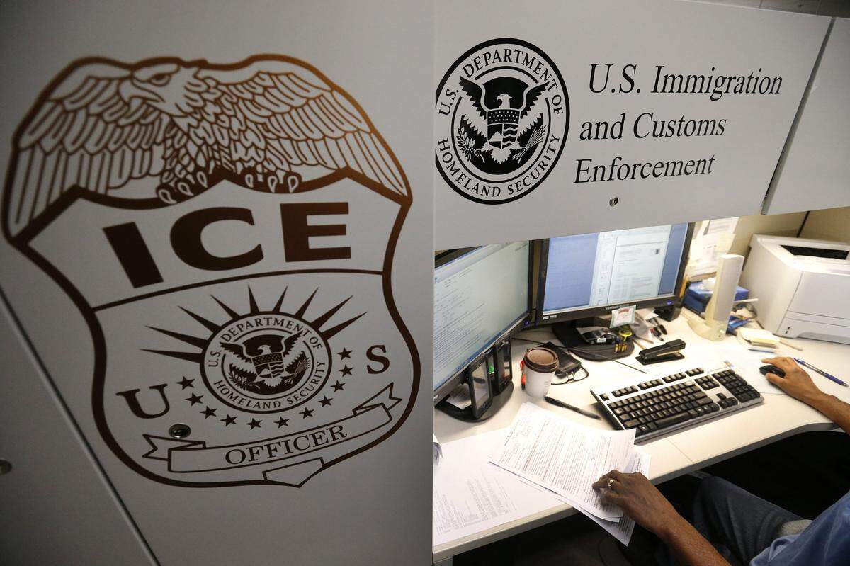 An unidentified Immigration and Customs Enforcement deportation officer reviews forms required to issue a detainer asking local law enforcement to hold someone until ICE agents can pick the person up. (Allen J. Schaben/Los Angeles Times/TNS)